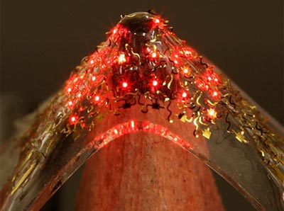 Photograph of an array of LEDs being stretched by a pencil tip